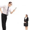 Image of big man using magnifying glass to scrutinize employee representing whether employers can find the employee privacy sweet spot