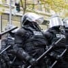 Image of police officers in riot gear representing government control in the context of the recent U.S. vs Apple case
