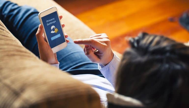 Image of woman using mobile phone showing privacy settings representing how telco will give consumers better privacy control over data