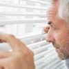 Image of boss peering between window blinds representing the impact of the EU GDPR on privacy in the workplace