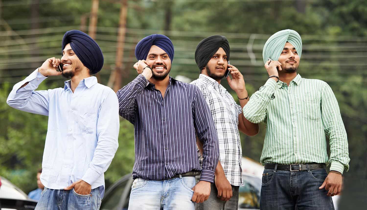 Image of Indians using their mobile phones representing cyber security standards mandated by the Indian government on phone makers