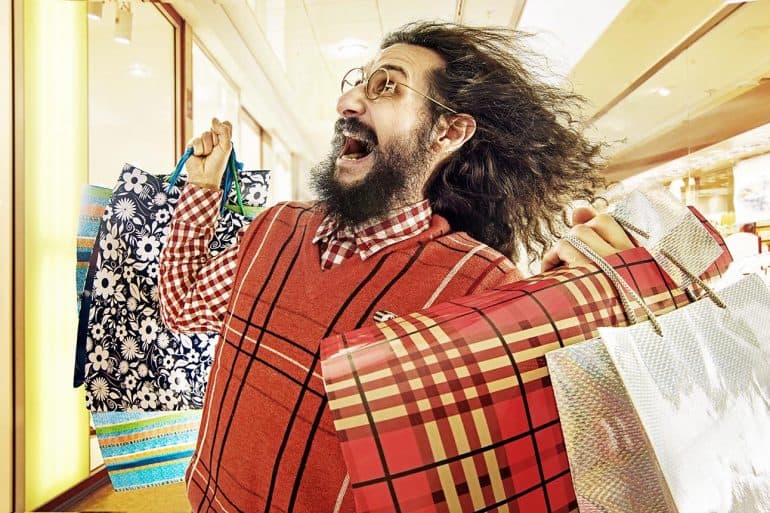 Image of man with crazy hair and carrying shopping bags being blown away representing how digital marketers have to comply with EU GDPR behavioral targeting guidelines