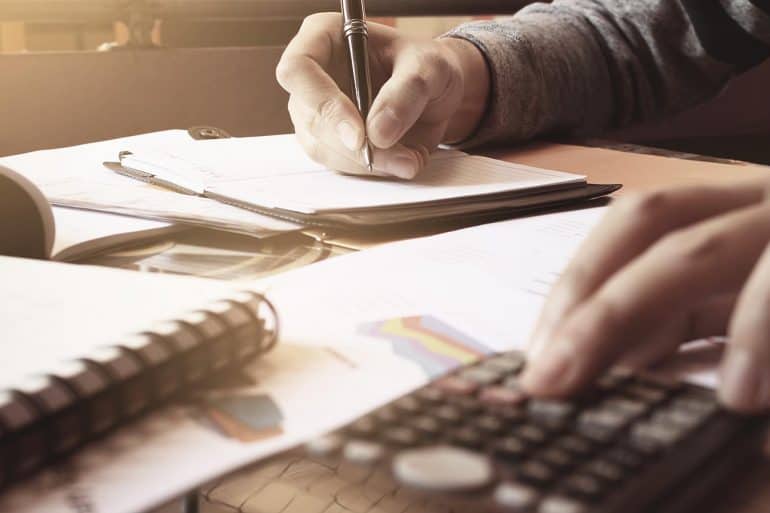 Image of man using calculator for doing accounts representing the GDPR compliance costs for the Global 500