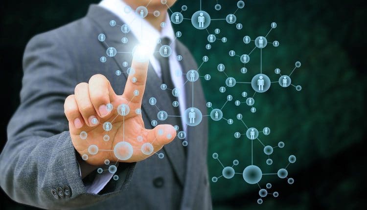 Image of man using finger to select a network of people representing invasion of privacy from the tracking of online behavior