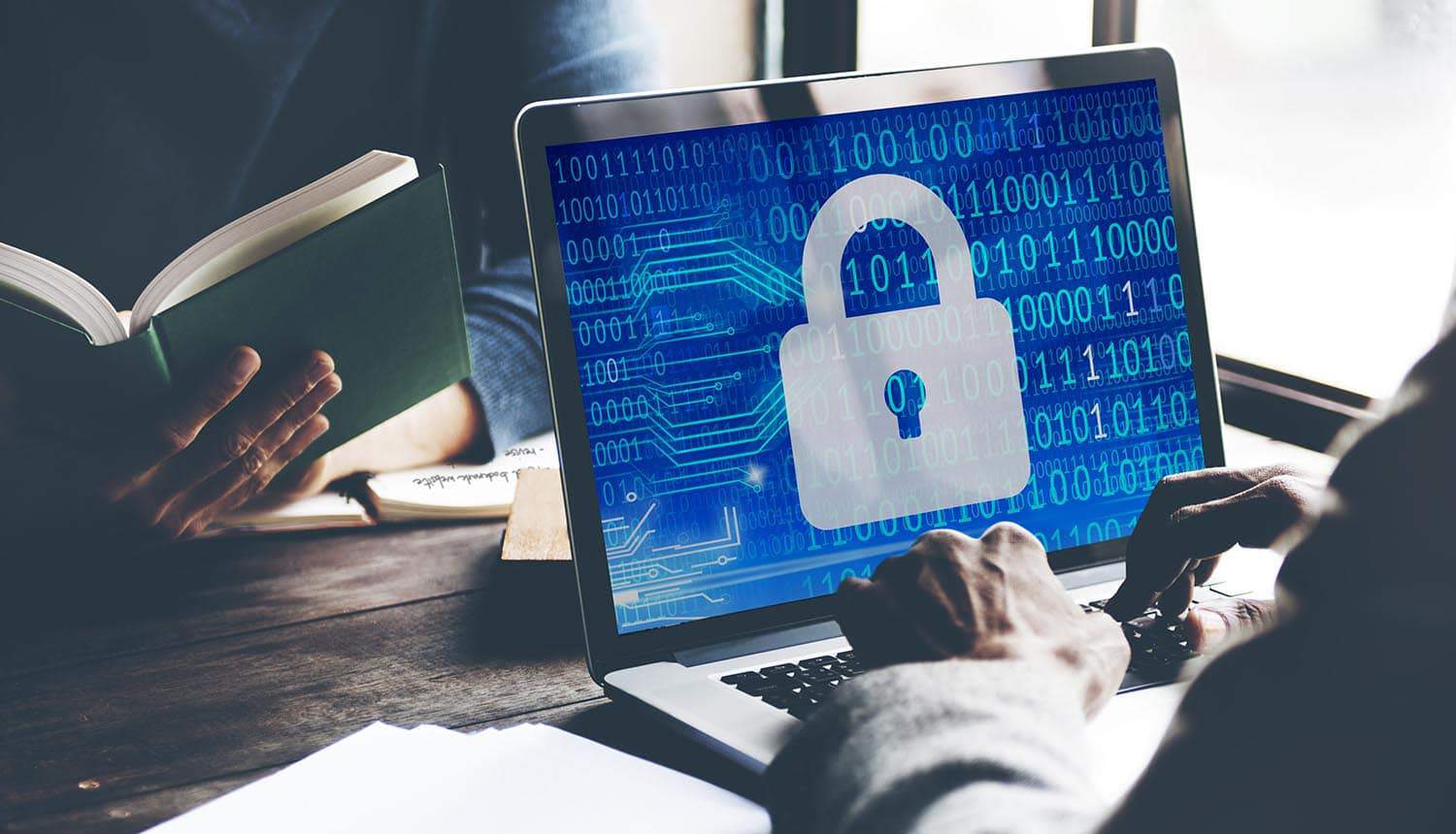 Image of man using laptop with lock on the screen representing the web security upgrade needed for U.S. federal websites