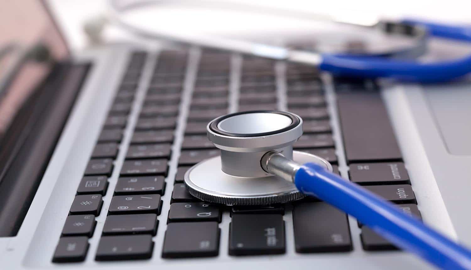 Image of stethoscope on laptop keyboard representing cyber risk benchmarking for cyber insurance