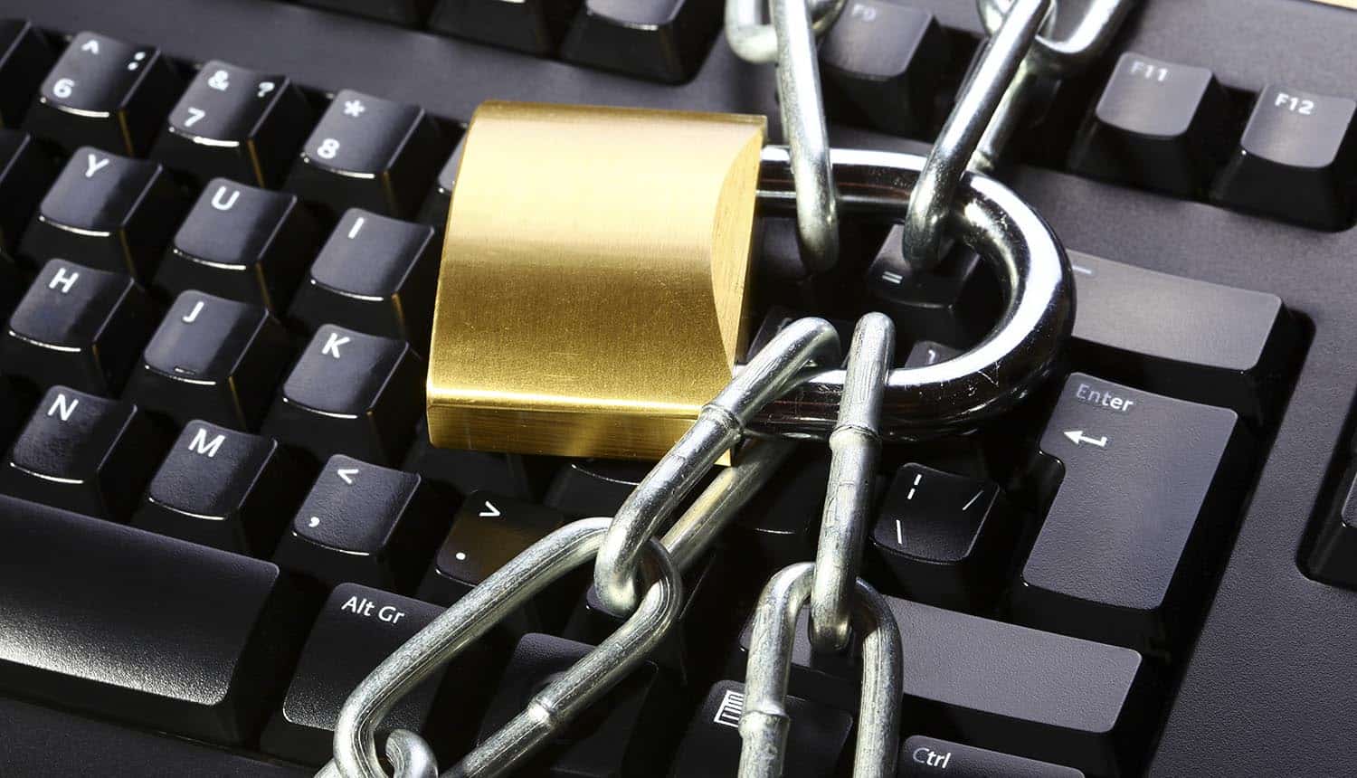 Image of lock and chain over keyboard signifying the need to protect the privacy of both home and business from ransomware