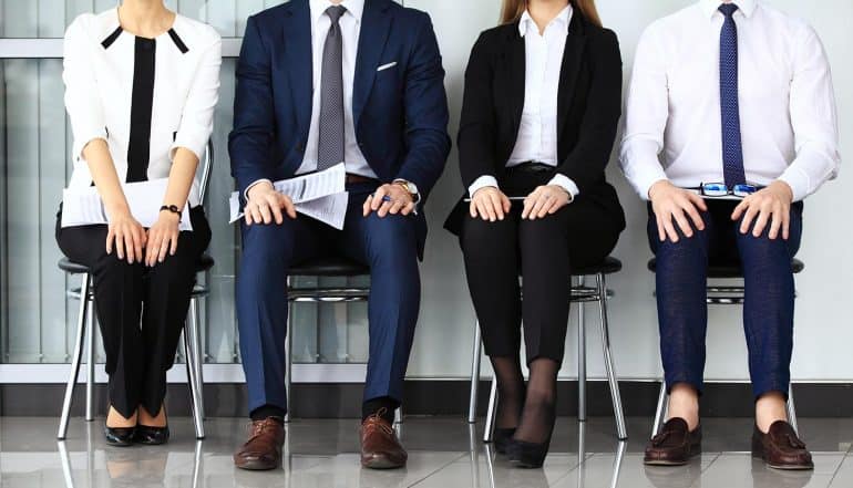 Image of four interview candidates sitting in a row signifying churn in cyber security jobs and how that makes it harder to fight cyber crime