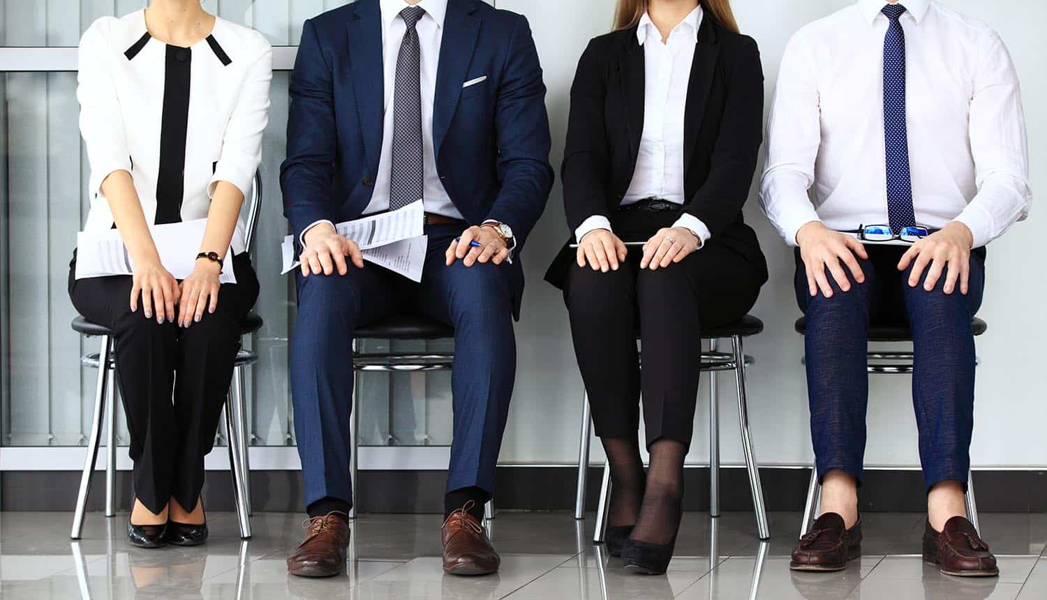 Image of four interview candidates sitting in a row signifying churn in cyber security jobs and how that makes it harder to fight cyber crime