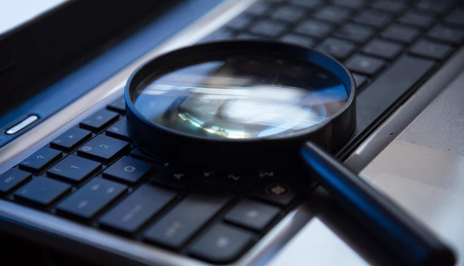 Selective focus on keyboard with magnifier searching concept in dark low key night tone