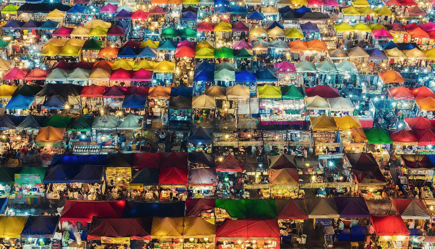 Photo of night market with colorful tents and retail shops