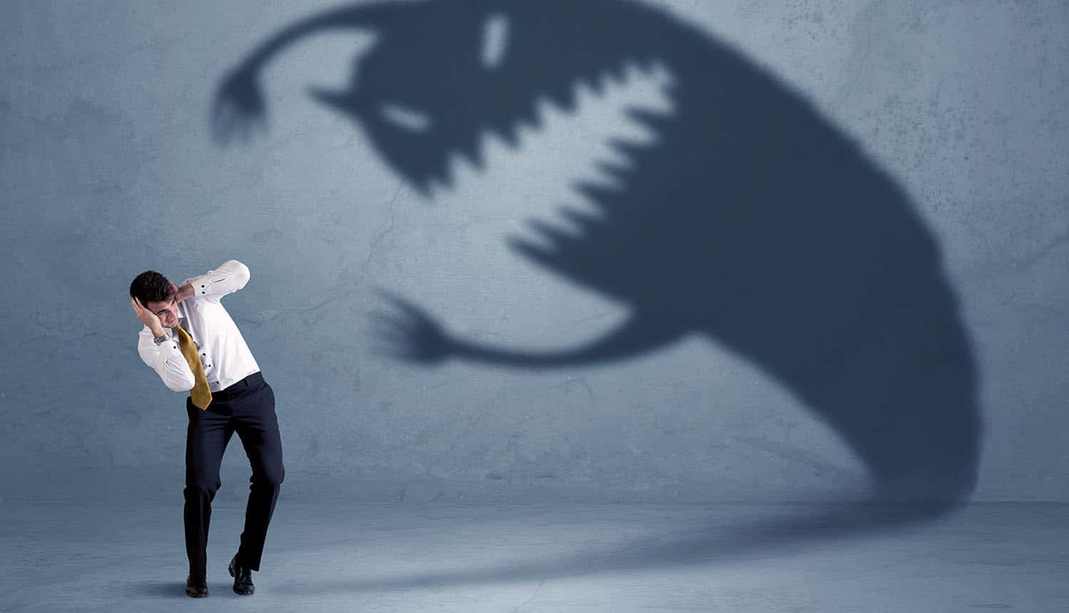 Image of business man afraid of shadow monster