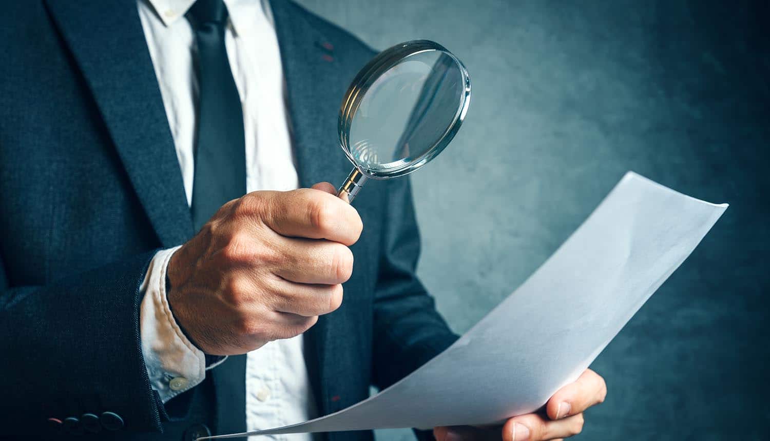 Regulator reviewing EU GDPR compliance documents through magnifying glass