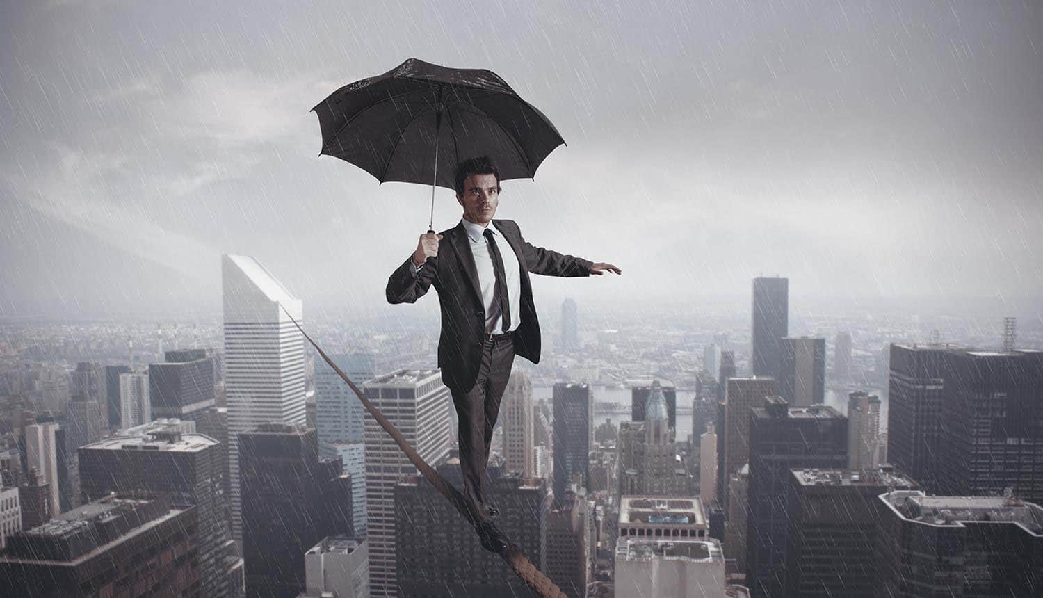 Privacy leader balancing on a tight rope carrying umbrella to shield against the rain showing the difficulty of balance and integration