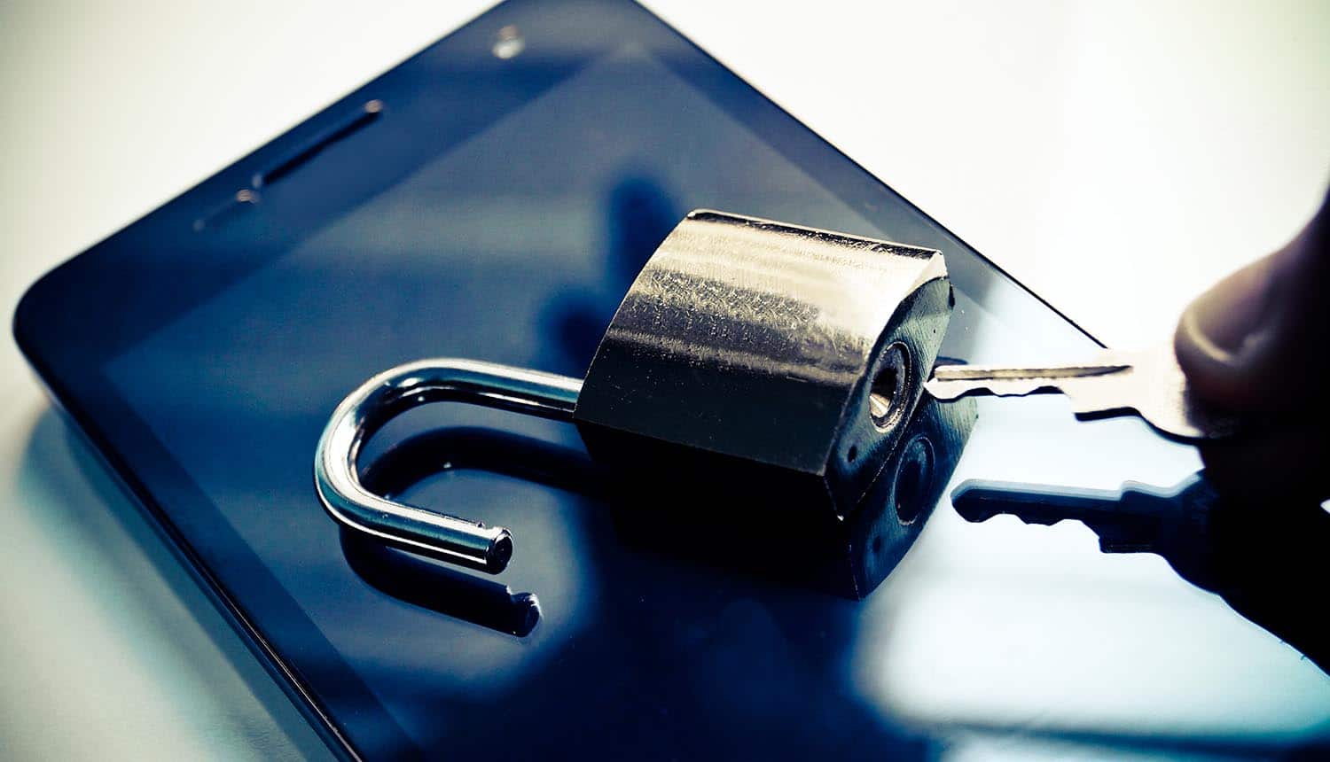 Hand with a key trying to open security lock on a smartphone showing Five Eyes wanting access to data from tech companies