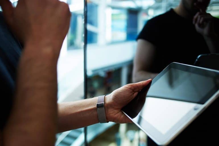 Business executive using wireless devices in modern office showing IoT in the workplace