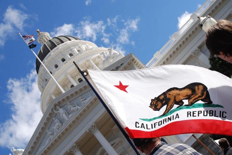 People carrying California state flag at the California State Capitol showing challenges for CCPA compliance