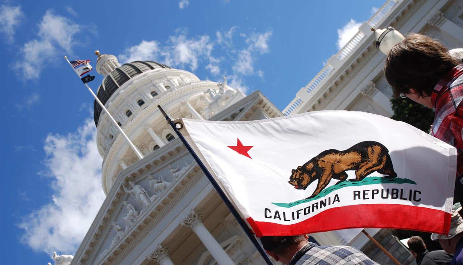 People carrying California state flag at the California State Capitol showing challenges for CCPA compliance