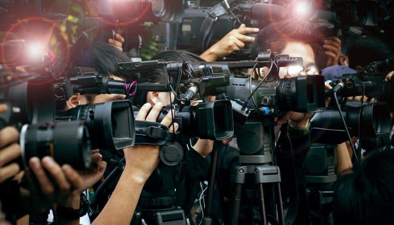 Press and media camera video photographer at press conference showing the need to protect corporate reputation with effective data breach response