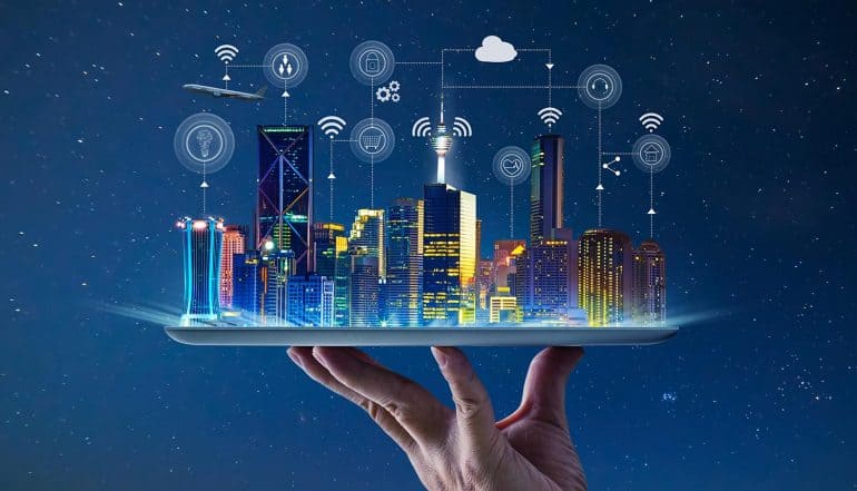 Hand holding an empty digital tablet with Smart city with smart services and icons of internet of things showing smart cities embracing digital rights