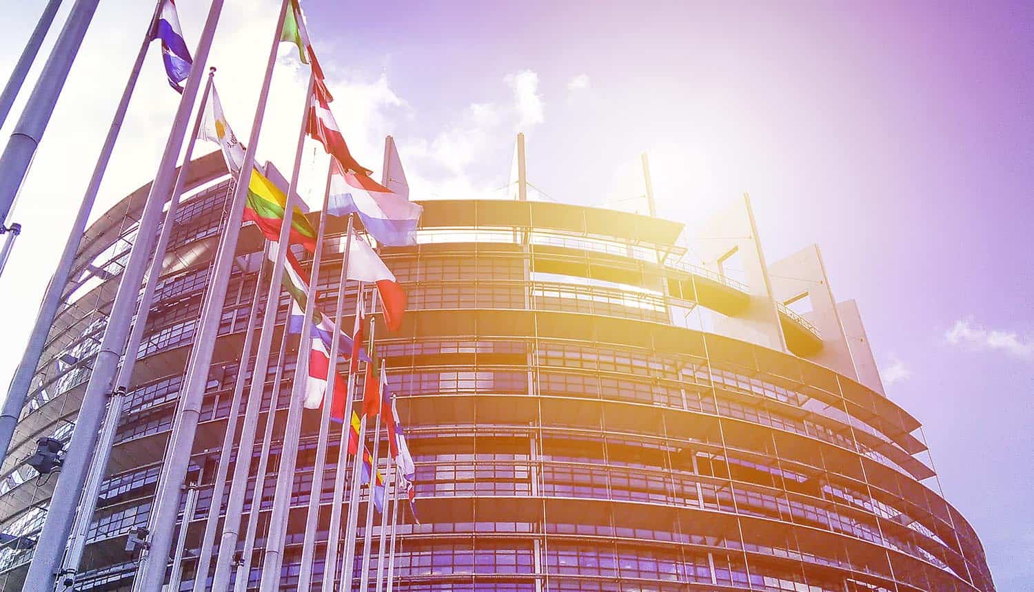 EU Parliament building with flags in sun light showing a new era for privacy regulations and GDPR