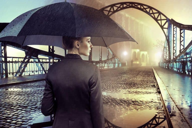 Businesswoman standing in the rain holding umbrella showing that cyber insurance coverage may not be what was expected