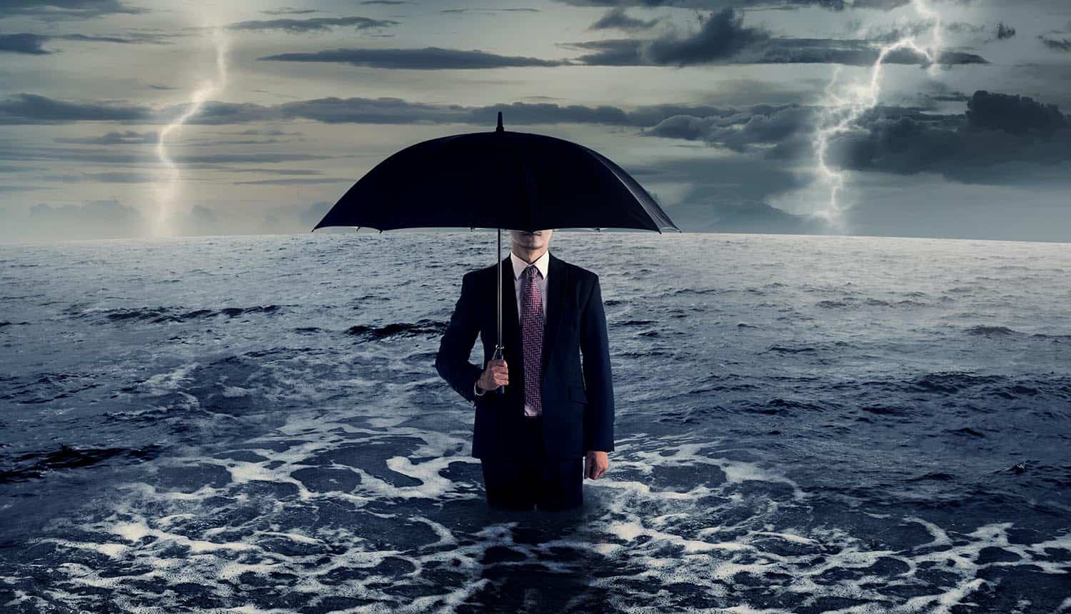 Business man standing on the sea in the middle of storm showing cyber insurance may not cover cyber war
