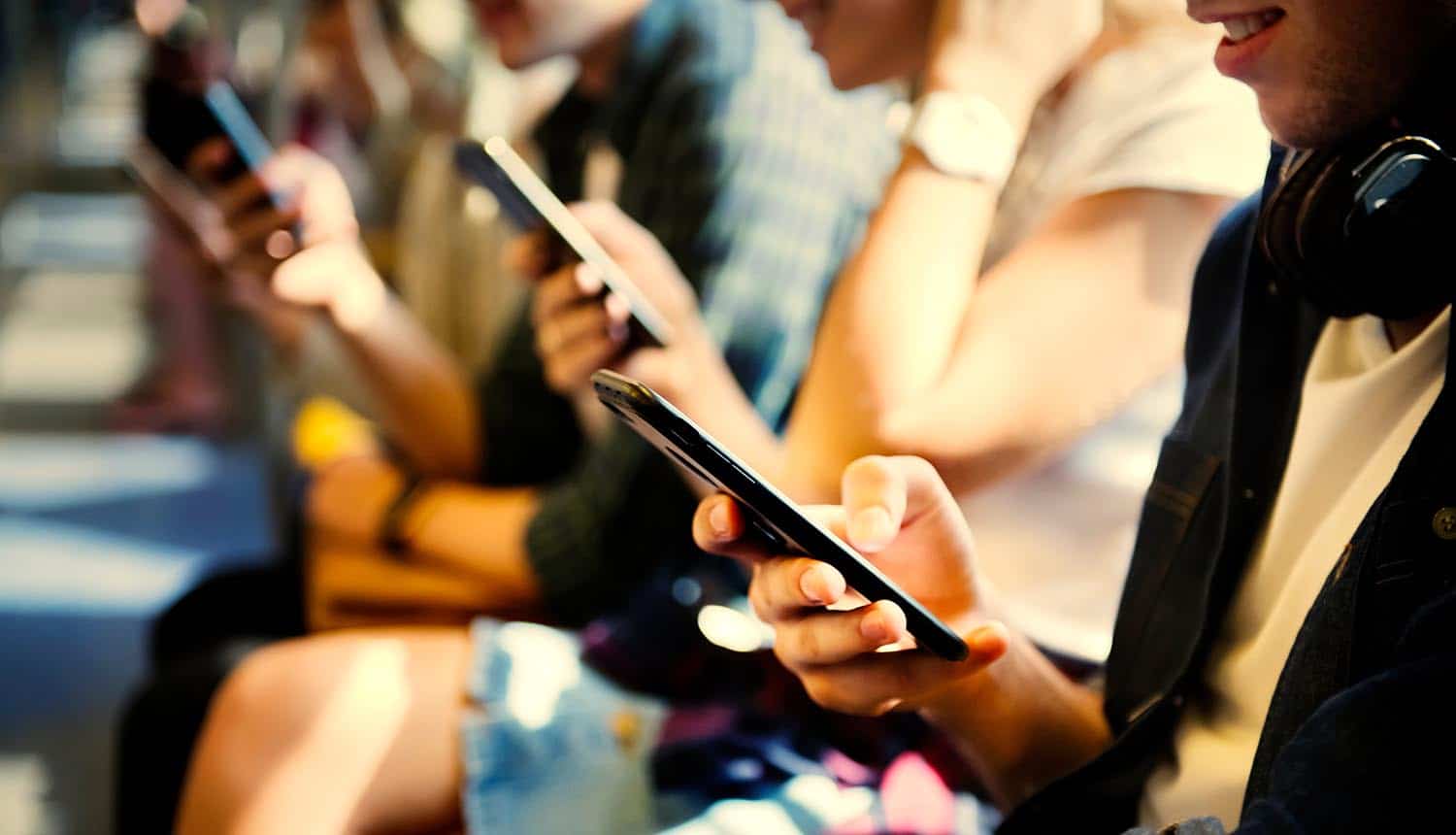 Young people using their smartphones showing that they will not pay for online privacy