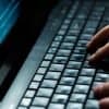 Hacker using laptop to execute a cyber heist