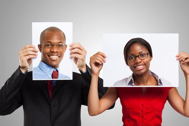 Man holding a portrait of another smiling person showing the threat of deepfakes in cybersecurity