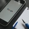 Google app in iPhone screen, placed on a black work space showing Apple's consumer privacy business strategy