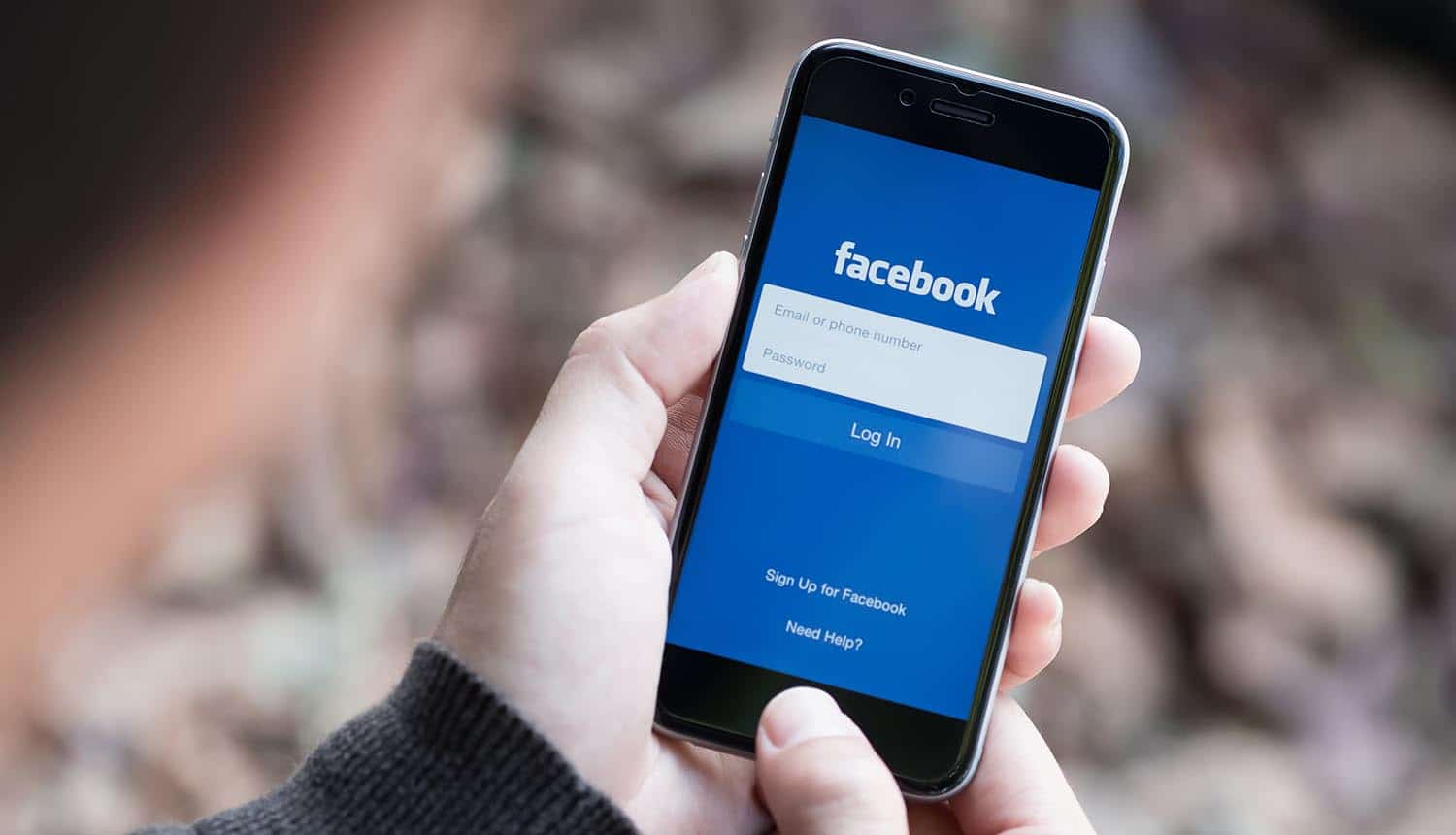 Man holds Apple iPhone with Facebook application on the screen showing new ruling on data collection practices