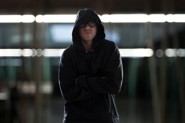 Hacker looking smug and standing with arms crossed showing the need for faster cyber response