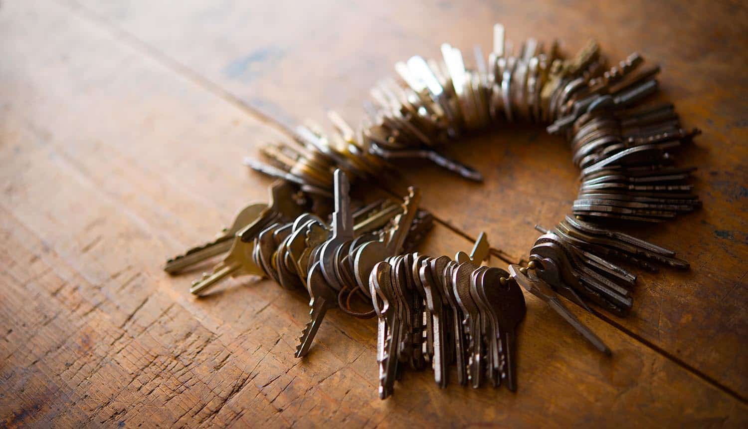 Many old keys on a well used old wooden desk show security flaws in password managers