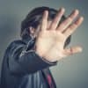 Celebrity is hiding face with a hand from newspaper photographers