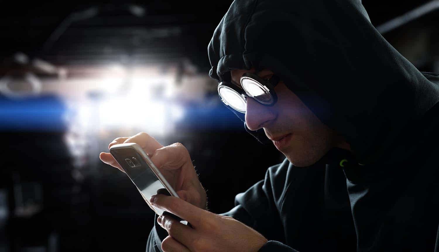 Hacker touching a smart phone screen showing how hackers attack mobile apps and the methods to protect against it