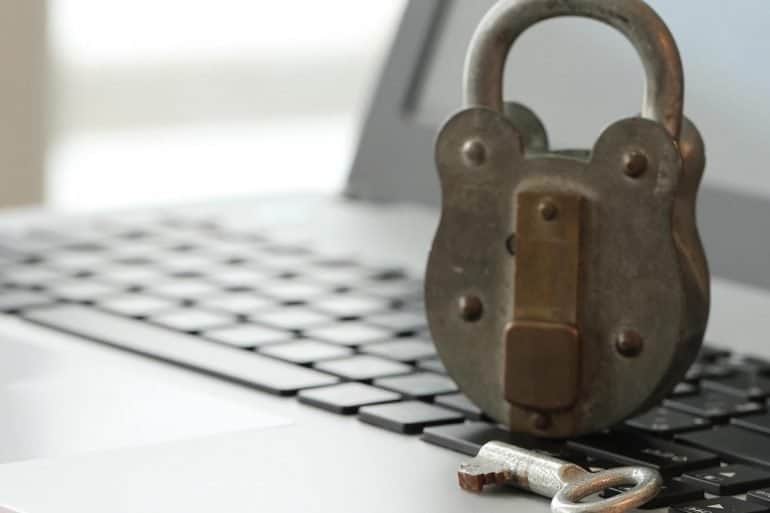 Old padlock and key on laptop computer keyboard showing the need for small businesses to stay safe online