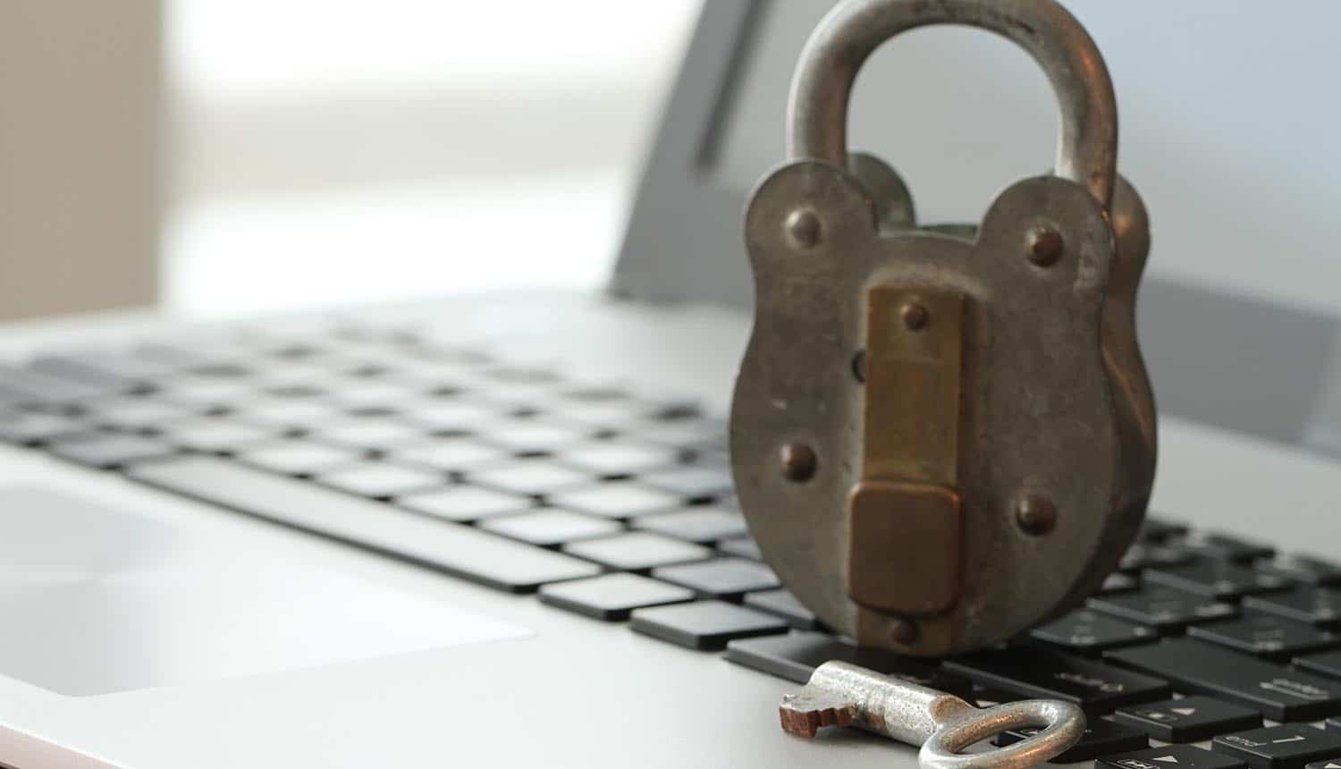 Old padlock and key on laptop computer keyboard showing the need for small businesses to stay safe online