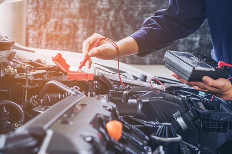 Car mechanic testing car engine showing new cyber insurance initiative modelled similarly to automotive industry