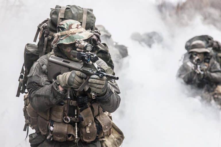 Group of soldiers in the smoke showing the use of active cyber defense with private sector bounty hunters