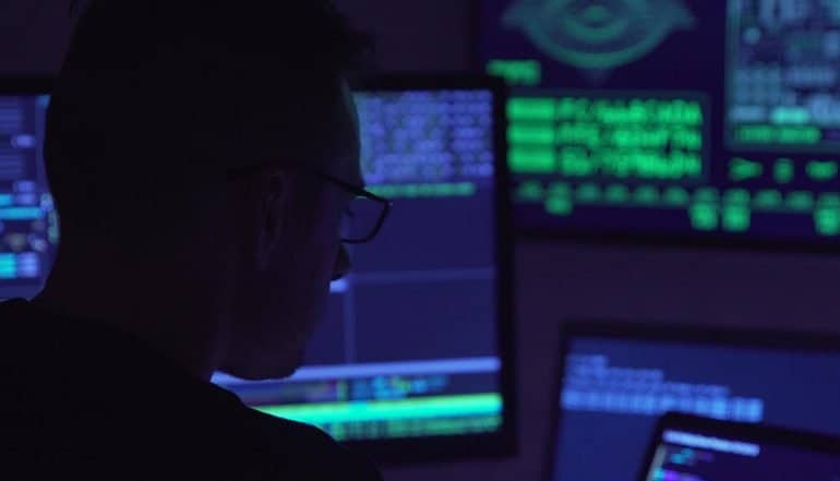 Hacker working on computer showing new wave of hacking through AI-powered malware, smart phishing and open source attacks