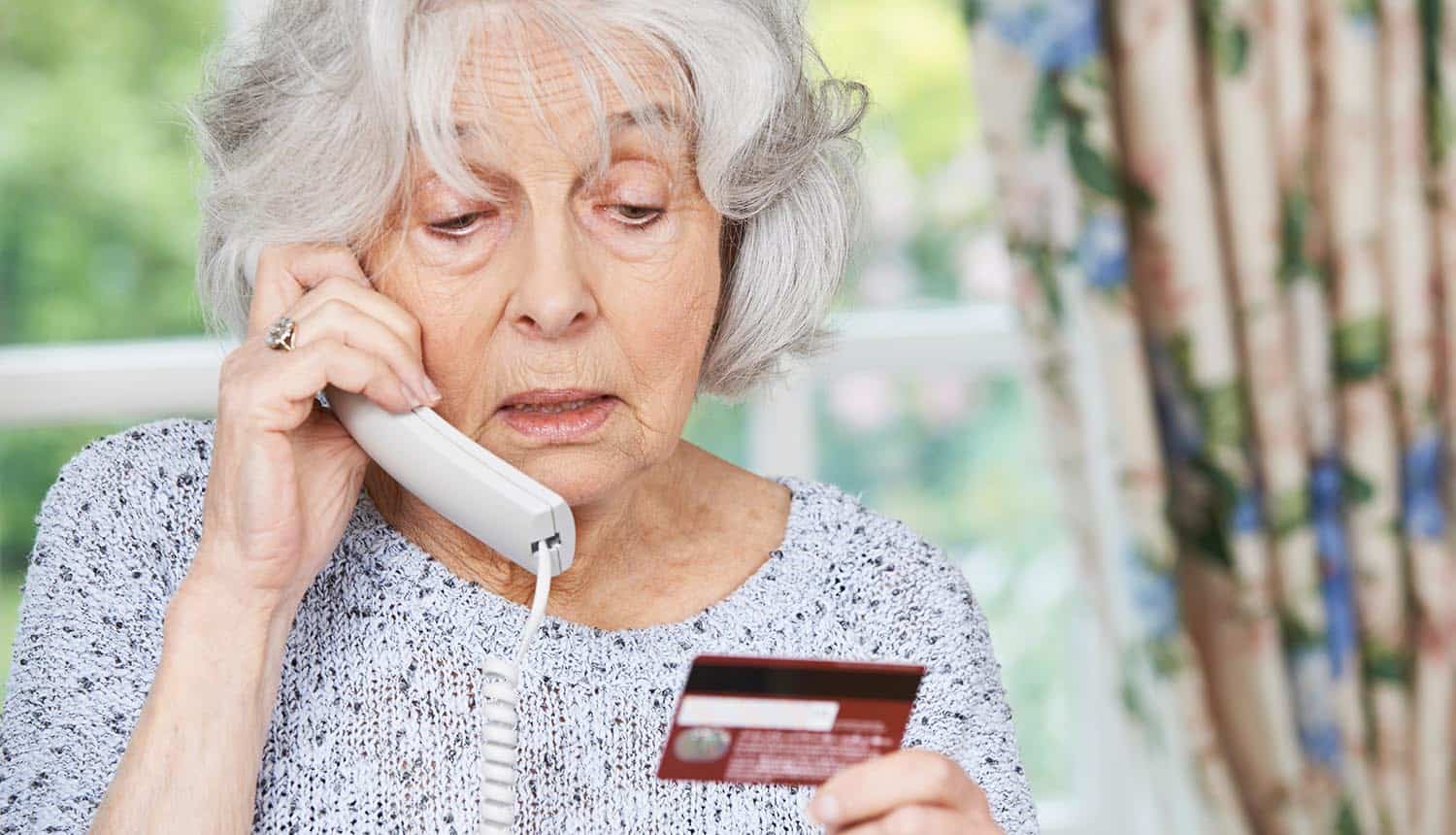 Senior woman giving credit card details on phone showing $2.7 billion in personal and business losses through internet crime