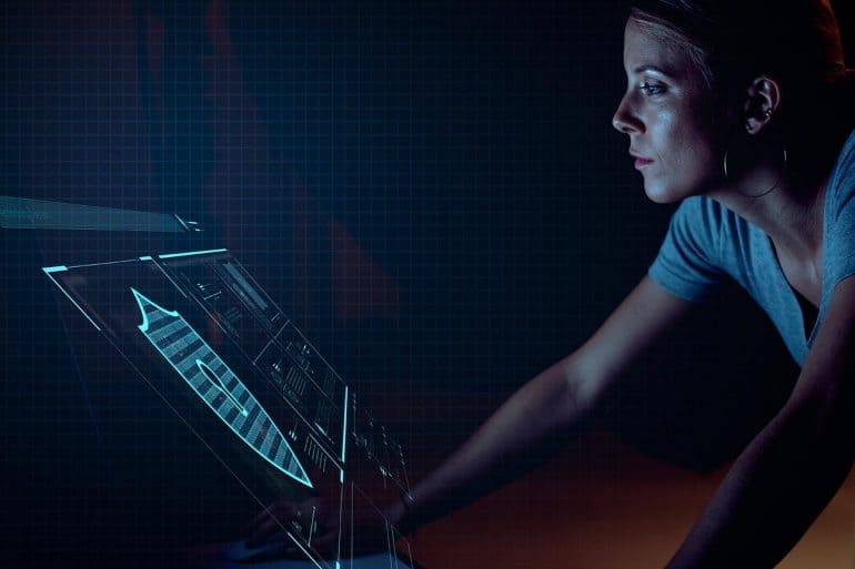Woman analyst in front of futuristic security screen showing changing threat landscape highlighted by Verizon data breach report