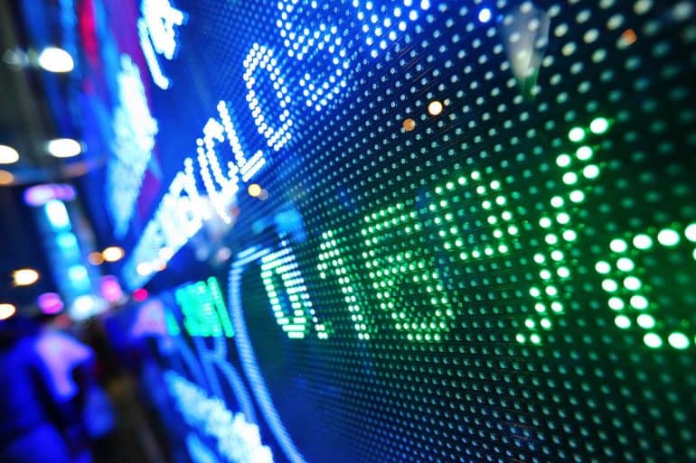Display of stock market prices showing financial Impact of massive data breach on Equifax downgrade