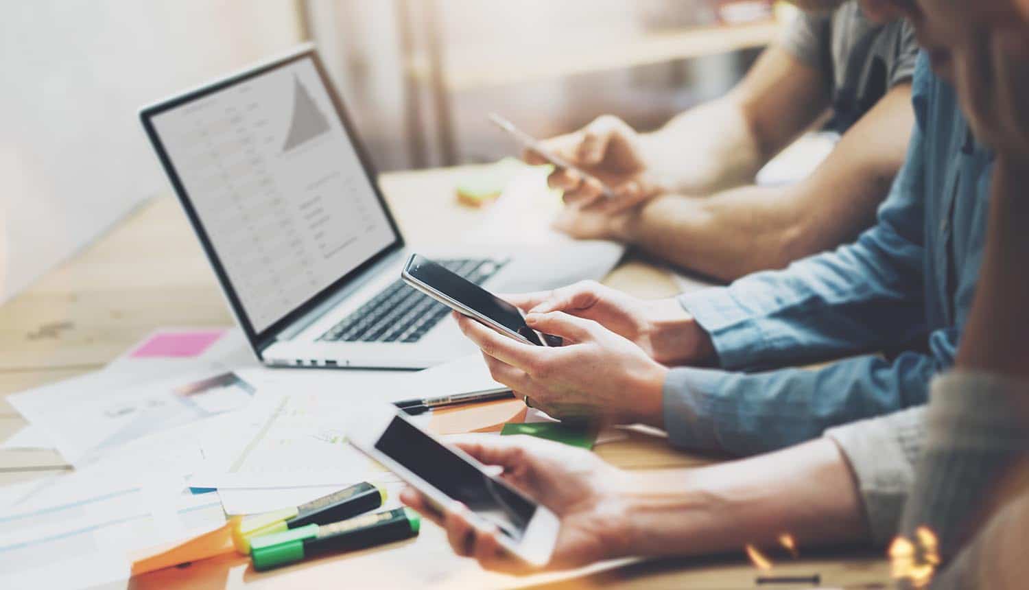 Employees using mobile phones showing the security threats of fake mobile apps