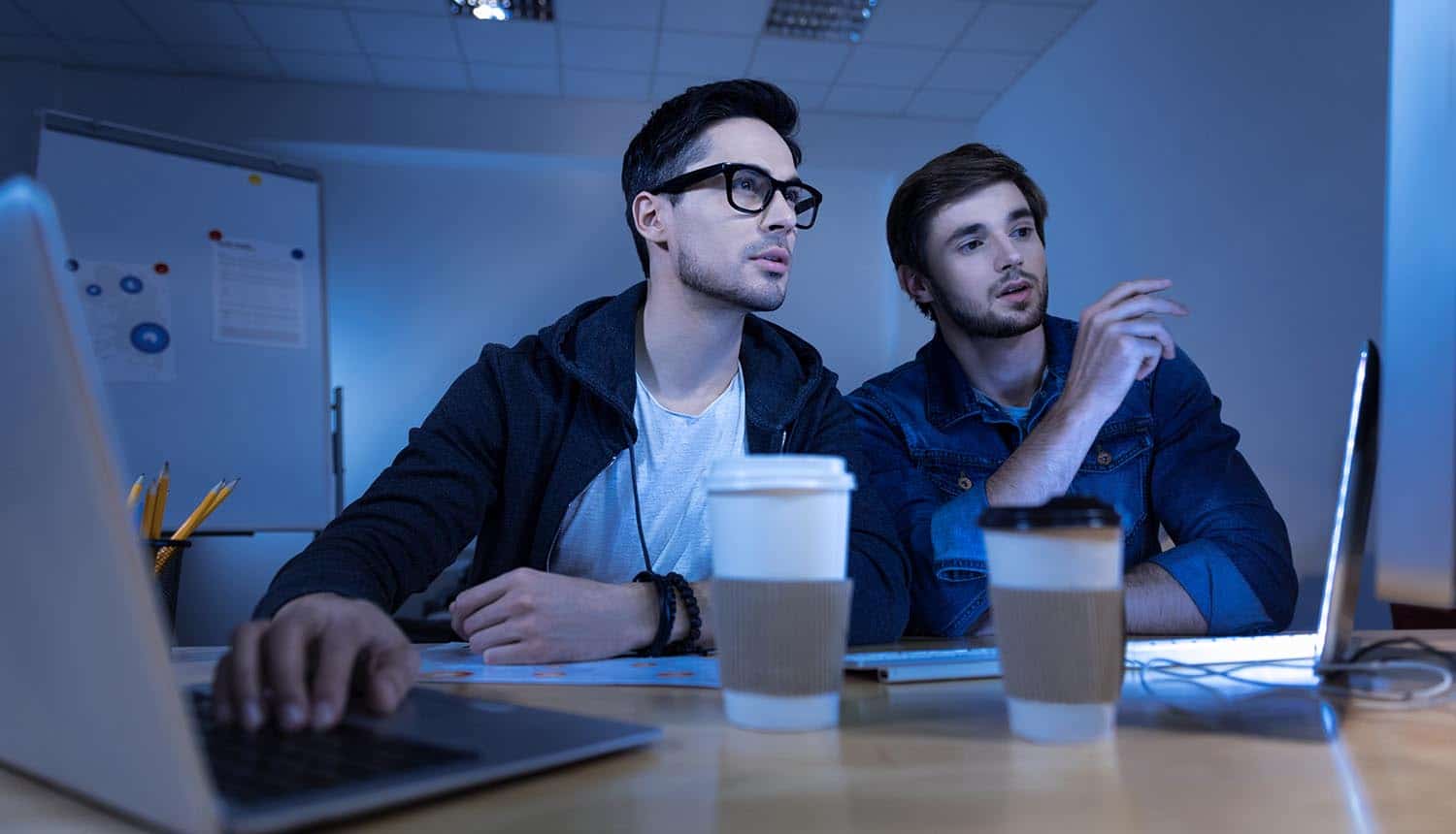 Men discussing work over laptop showing the points which make up the structure of a good penetration test