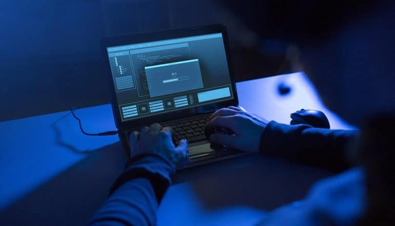 Hacker working on laptop showing the five ways to prevent Capital One Breach from happening to organizations
