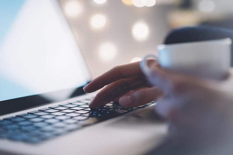 Woman using laptop showing the main benefits of using new MacOS Catalina for data privacy