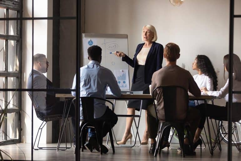 Business people in a meeting showing the need for IT security leaders and board members to accept more responsibility for cybersecurity risk