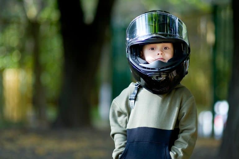 Kid with a big motorcycle helmet on his head showing politicians warning FTC against weaking COPPA